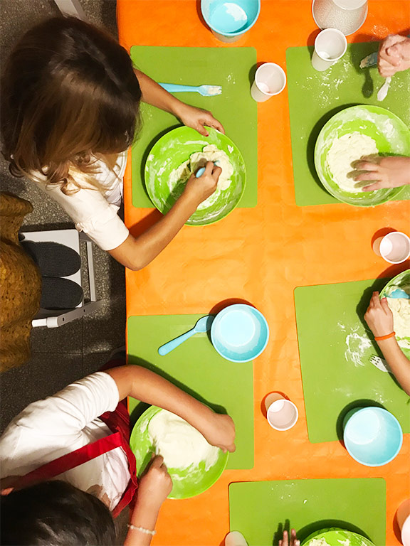 foto di bambini che preparano la pizza